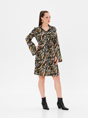 Pregnant girl model in stylish clothes on white background in studio.