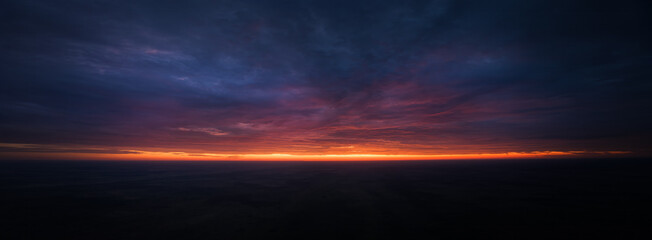 Ideal for sky replacement projects: Dramatic Colorful sky at sunrise over the Central Kalahari Game Reserve in Botswana.  No obstacles, panoramic view, aerial shot.