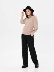 Pregnant girl model in stylish clothes on white background in studio.