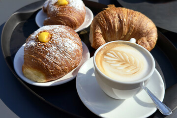 brioche e cappuccino italiano, tray with croissants and italian cappuccino	