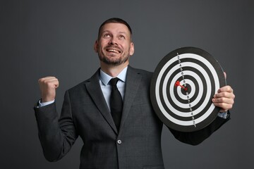 Targeting. Man with dart board and arrow on grey background
