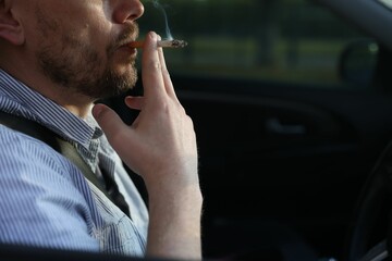 Man smoking cigarette in car, closeup. Space for text © New Africa