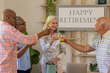 Senior friends celebrating retirement with joyful toast and smiles at home