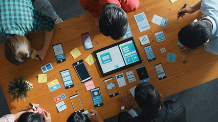 Top view of software developer team looking Ux Ui design for mobile phone interface from tablet...