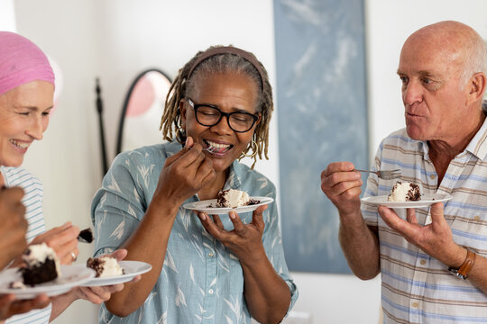 Naklejki Senior friends enjoying delicious cake together, sharing laughter and joyful moments