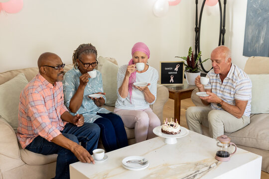 Naklejki Senior friends enjoying coffee and cake together, celebrating cancer survivor