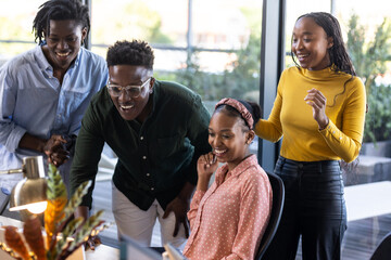African American colleagues collaborating on project at office, smiling and engaged