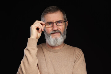 Fototapeta premium Portrait of mature man in glasses on black background