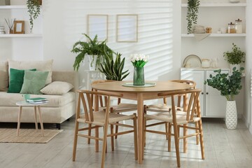 Comfortable sofa, table, chairs and green houseplants indoors. Interior design