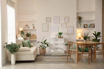 Stylish dining table with chairs and comfortable sofa in room. Interior design