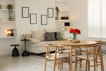 Beautiful red tulips in vase on wooden table indoors, space for text