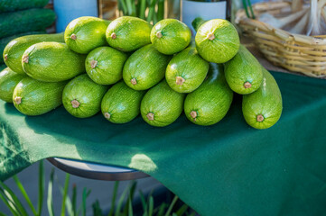 Close-up of young bright green zucchini on a farmer's market counter