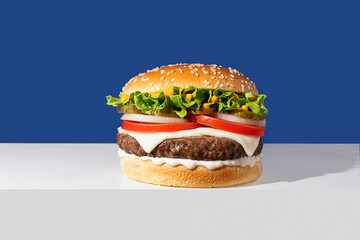Classic cheeseburger on a blue background with vibrant colors