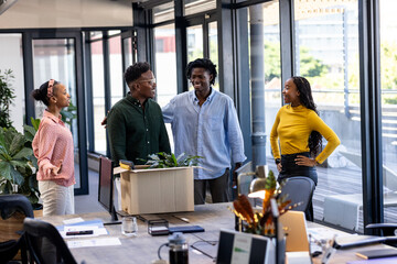 African American colleagues celebrating new team member in modern office setting