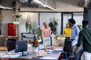 Diverse team collaborating in modern office, discussing project with enthusiasm