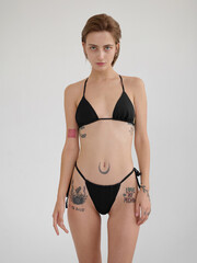 Fototapeta premium Girl model posing in studio on light background.