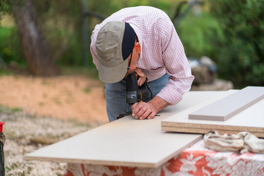 Senior man focused on carpentry in outdoor setting