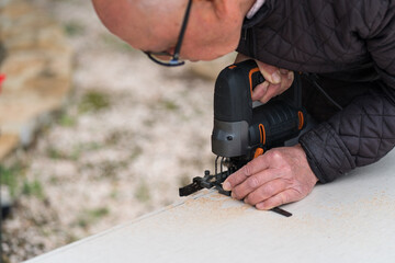 Senior man engaging in outdoor carpentry using power tool