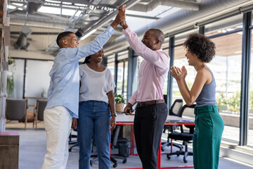 Obraz premium Colleagues in office celebrating success with high fives and smiles