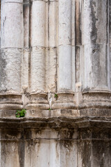 A close-up of an aged stone section exhibiting weathered textures, visible cracks, and natural...