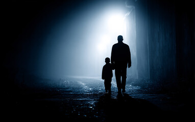 silhouettes of father and child walking together in darkness illuminated by dramatic beam of light symbolizing trust protection connection and emotional guidance
