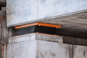 Bridge resting on seismic isolators to absorb shock waves during earthquake, ensuring structural integrity and safety