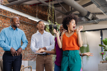 Celebrating success, African American colleagues expressing excitement and joy in office