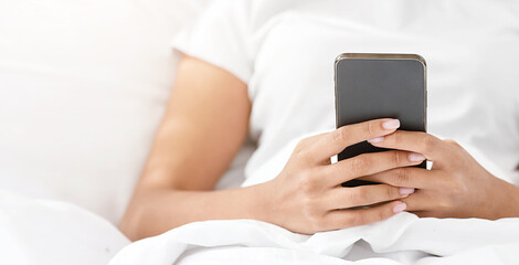 Great offer and message, app, ad, online chat during self-isolation. Happy millennial cute african american lady sitting on bed with smartphone, in cozy bedroom interior, selective focus, cropped