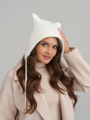 Feminine model showcasing winter fashion in a stylish studio environment