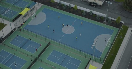 Epic, cinematic drone shot over public soccer court and people playing - Powered by Adobe
