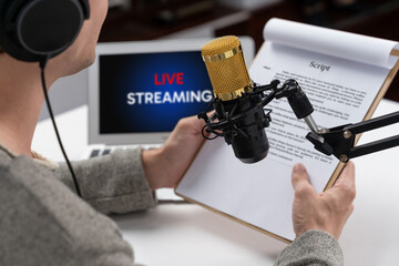 Host channel in smart broadcaster with talking show on live social media streaming with script note reading to listeners, wearing headphones to record video streamer at modern home studio. Pecuniary.