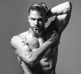 Sexy athletic muscular man taking shower, washing with soapy sponge in bathroom. Men's shower...