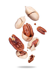 Crushed pecan nuts in the air close-up isolated on white background