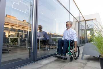 Mature man on a wheelchair looking determined and confident