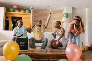 Fototapeta premium Celebrating new job, friends cheering with balloons and confetti in living room