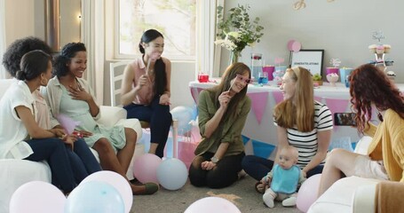 Group of happy multiracial and white female friends with baby taking pictures at a baby shower party - Powered by Adobe