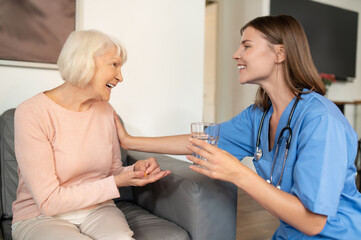 Fototapeta premium Nurse providing healthcare assistance support and care for elderly patient