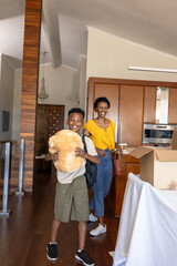 Fototapeta premium Mother and son unpacking boxes at home, smiling and enjoying new space