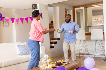 Couple enjoying festive celebration at home, sharing snacks and drinks together