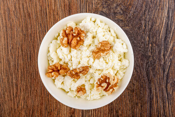 Top view of fresh cottage cheese with walnut pieces.