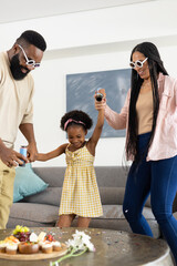 African American family dancing together at home, enjoying quality time and laughter © wavebreak3