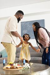 African American family dancing together at home, enjoying quality time and laughter © wavebreak3