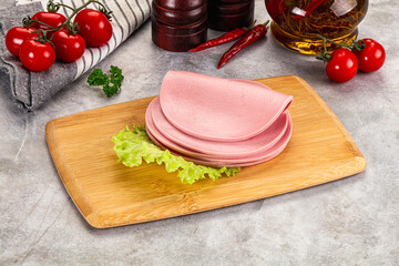 Sliced boiled sausage over board