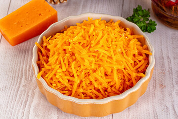 Yellow shredded cheddar cheese in the bowl