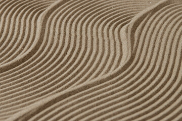Japanese zen garden for meditation, texture / background with lines in sand for relaxation, balance and harmony, spirituality or spa, calm pastel beige.