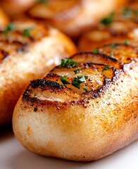 Deliciously grilled bread rolls topped with fresh herbs, perfect for enhancing any meal. Ideal for showcasing culinary skills or capturing food's appealing aesthetics.