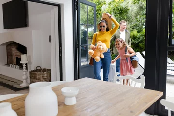Family arriving home with luggage and teddy bear, smiling and excited © WavebreakMediaMicro