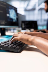System administrator in server farm using AI systems, typing on keyboard, inputting data. Close up of data center technician using artificial intelligence parallel processing tech on computer