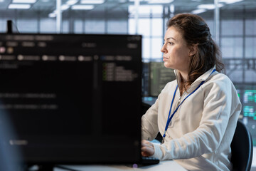 Computer scientist in server room implementing power management solutions to reduce energy consumption. Woman using PC, integrating new technologies and systems in data center