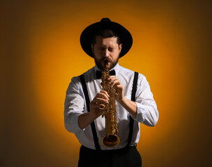 Professional musician playing soprano saxophone on color background